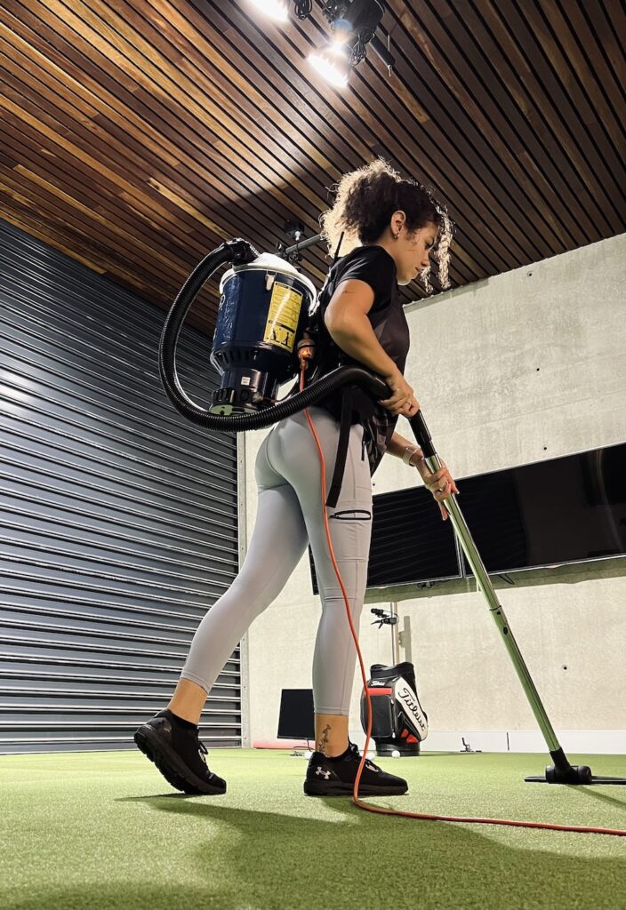 Inticlean staff using backpack vacuum for gym carpet cleaning during commercial service session