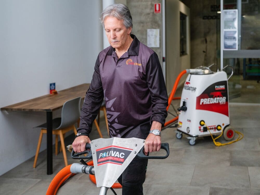 IntiClean staff member using POLIVAC floor cleaning machine inside office building